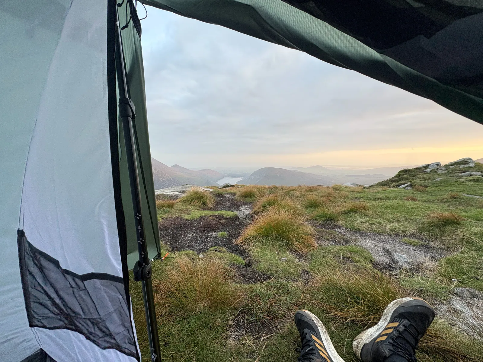 Looking out of the open door of the Durston X-Mid 2, trekking-pole pitch and boots up, across the Mourne Mountains at dusk